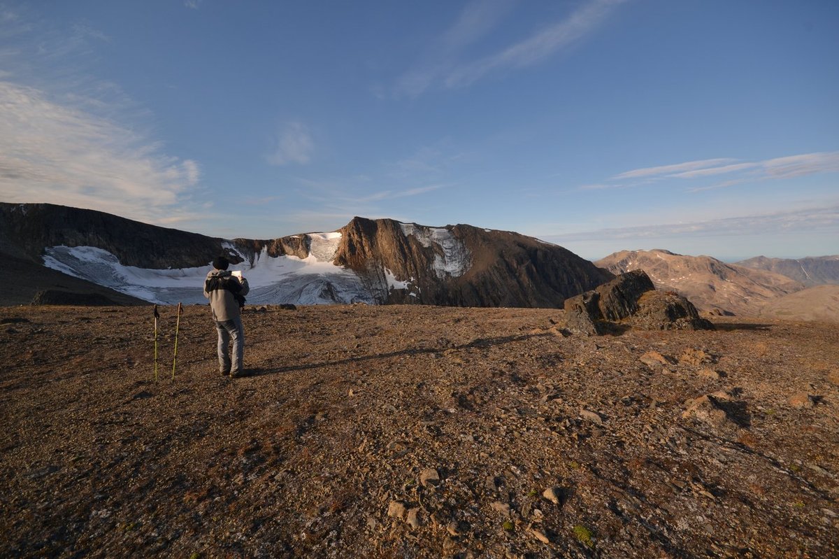 Field team member at golden hour looking toward the accumulation area and the glacierized pass