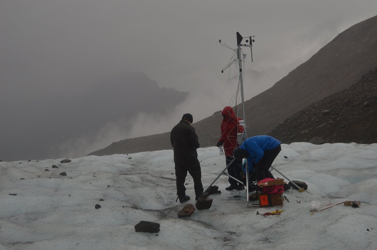 Installing a weather station on the glacier surface during the 2014 field campaign