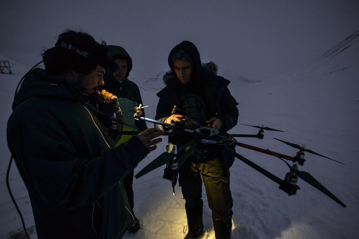 Team assembling the hexacopter before a survey flight in Svalbard polar twilight. At 78°N in April, fieldwork windows are short and cold.