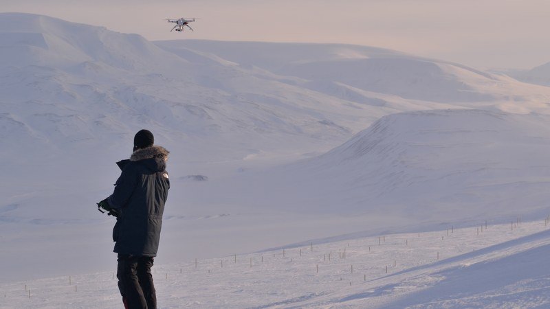 UAV operator flying drone over Svalbard snow, Longyearbyen
